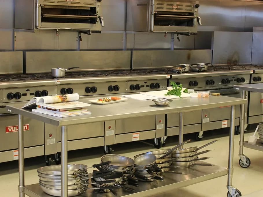 Stainless steel commercial kitchen with ranges and prep tables